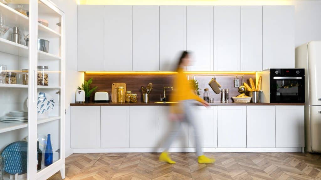 woman walking in front of laminate cabinets