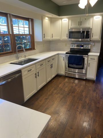 Kitchen cabinets refaced to a cream color with new black knobs and drawer pulls Kitchen cabinets refaced to a cream color with new black knobs and drawer pulls